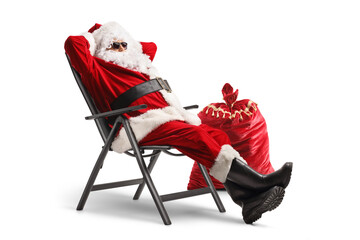 Poster - Santa claus wearing sunglasses and enjoying in a foldable chair