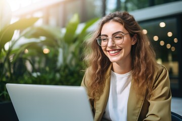 Smiling Woman Using Laptop with Stylish Glasses