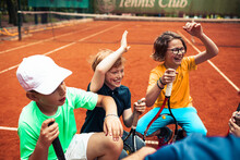 Joyful Young Tennis Players Having Fun On A Clay Court