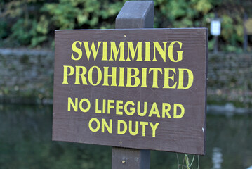 Wall Mural - swimming prohibited no lifeguard on duty sign at famous swimming hole (waterfall in ithaca) safety, life guard, drowning threat, water sport, swim, summer (no swimming allowed)