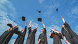 © Довидович Михаил - Joyful graduates stand in a row and toss their caps up in the air.