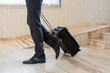 Businessman pulling personal luggage in a hotel lobby