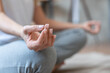 Closeup nails female hands serene mature woman athlete yogi meditating in lotus position with eyes closed at home. Clarity of mind, relaxation, stretching exercises