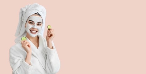 Wall Mural - Beautiful young woman with cucumber slices and facial mask on pink background with space for text. Cosmetology concept