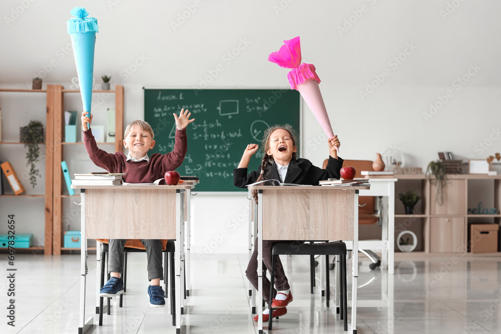 Classmates with school cones sitting at desks in classroom