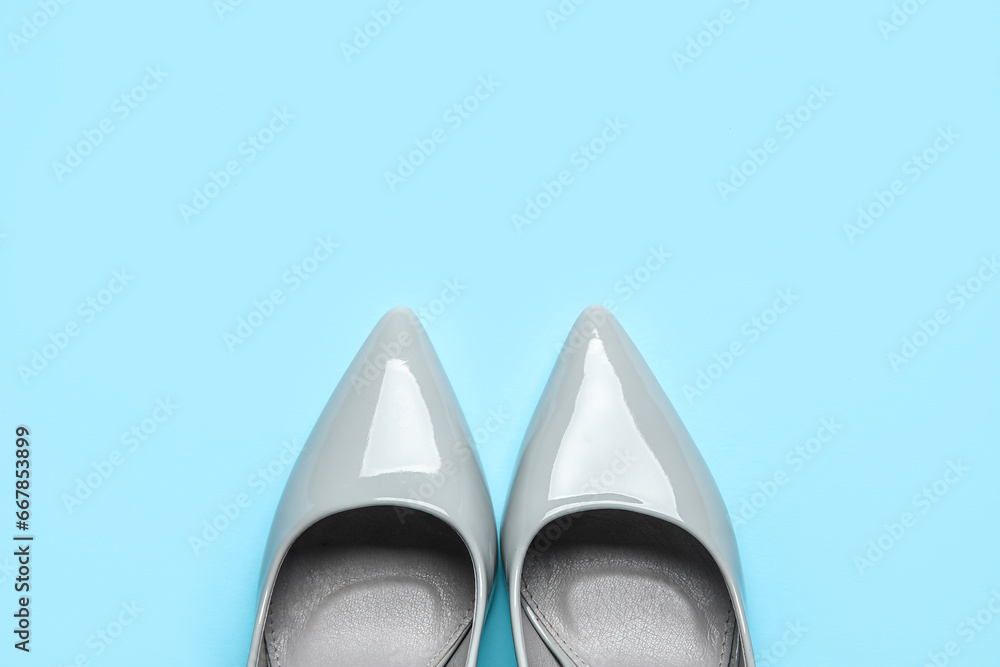Stylish grey high heels on blue background