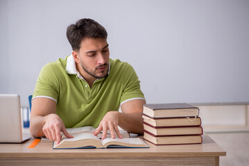 Wall Mural - Young male student sitting in front of whiteboard