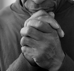 Wall Mural - black man praying to God on grey black background with people stock image stock photo