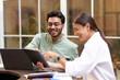 © Daria - Smiling business colleagues discuss biz issue while use laptop and digital tablet in office terrace