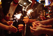 © maxbelchenko - Glowing sparkles in hands. Group of happy people enjoying party with fireworks. Winter holiday.