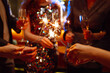 © maxbelchenko - Glowing sparkles in hands. Group of happy people enjoying party with fireworks. Winter holiday.