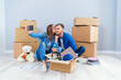 © gorynvd - Young couple taking selfies in their new home while sitting among cardboard boxes. Happy attractive young couple is moving, making a selfie, cuddling and smiling.