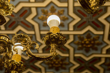 Vintage Golden Lamp Hanging From Painted Plaster Coffered Ceiling