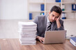 © Elnur - Young male employee and too much work in the office