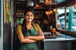 © VisualProduction - Beautiful young indian female food truck owner standing behind counter and smiling, successful business owner inside her food truck