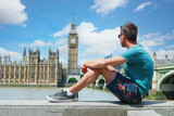 Fototapeta Big Ben - a young men tourist on a city trip in London looking at the Big Ben at Westminster Bridge