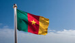 Close up view of an Cameroon flag waving on a flagpole, with blue sky background and copy space