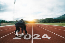 Happy New Year 2024 Symbolizes The Start Of The New Year. Woman Preparing To Run On The Athletics Track Is Engraved With The Year 2024. Start Challenge Goal Of Planning Health And Business To Success