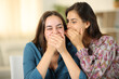 © Antonioguillem - Woman telling funny secret to her friend