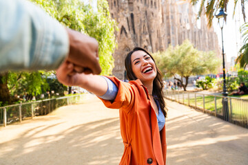 Multiracial beautiful happy couple of lovers dating at Sagrada Familia, Barcelona - Multiethnic tourists travelling in Europe and visiting a city in Spain, concepts about tourism and people lifestyle