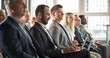 © Gorodenkoff - Multiethnic Man Sitting in Crowded Auditorium at Conference. Middle Eastern Businessman Listening To Keynote, Typing On Laptop. Specialist Watching Technology Presentation About Software Solutions.