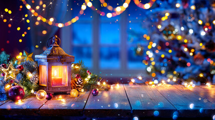 Wall Mural - Lantern And Christmas Tree Glowing On Table With Decoration And String Lights - Bokeh And Glittering Effect On Background