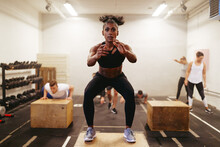 Fit Woman Doing Box Jumps During Her Workout Class