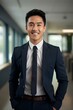 © yj - a beautiful smiling asian american man wearing a suit in an office. generative AI