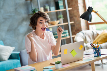 Photo of crazy overjoyed crazy funny young woman brown bob hair wear pink t shirt fists sit armchair workplace indoors her project done