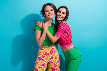 Wall Mural - Photo of sweet cute ladies wear colorful clothes smiling embracing isolated blue color background