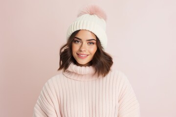 Wall Mural - Cheerful young woman in winter outfit looking at camera and smiling.