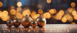 Golden christmas baubles on wooden table with bokeh background.
