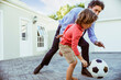 © Marko Geber - Engaged father teaching his son the nuances of soccer in their backyard