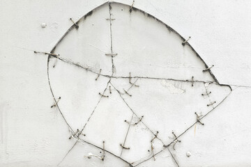 white broken wall was fixed by metal wires.