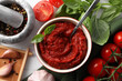© New Africa - Tasty tomato paste in bowl and ingredients on table, flat lay