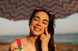 Woman using sunscreen cream. Beautiful woman with sun protection cream. Girl enjoy at the beach.