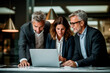 © GustavsMD - International diverse professional executives team workers or partners looking at laptop computer analyzing digital financial banking data corporate management working in office at group meeting