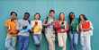 © Gigi Delgado - Group of multiethnic young people using mobile phone outdoor. Friends having fun with new trends social media apps. Youth technology addicted. University students isolated in blue background.