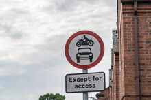 A road sign prominently displays a no entry symbol for both cars and motorcycles, complemented by an additional sign below stating Except for access.