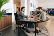 © dikushin - Wide shot of happy client male purchasing automobile in dealership, signing paper, shaking hands with car dealer in suit enjoying successful agreement. Concept of buying new auto at showroom.