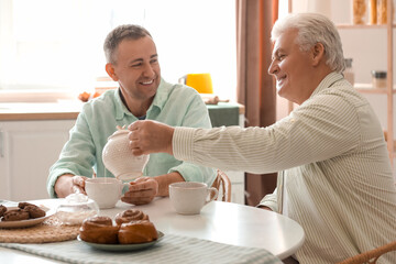 Poster - Mature brothers drinking tea in kitchen