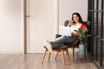 Wall Mural - Female technical support agent with laptop working at home