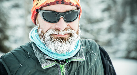 Wall Mural - trail runner with frozen beard training in winter landscape