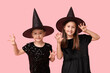 © Pixel-Shot - Cute little girls dressed for Halloween as witches on pink background