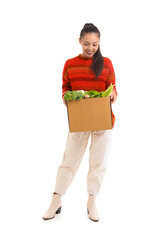 Wall Mural - Young Asian woman with shopping box full of fresh food isolated on white background