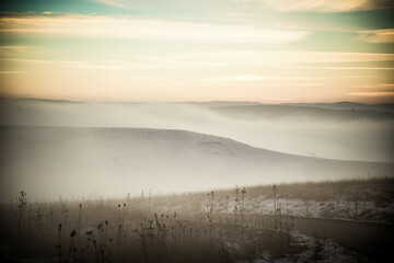 Wall Mural - moody winter landscape with fog at sunset