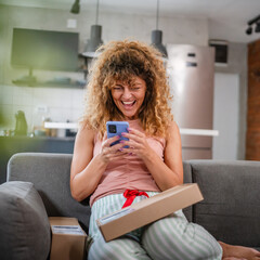 Wall Mural - one woman checking box of received package or product at home