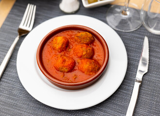 Wall Mural - Service plate containing meatballs in rich tomato soup with necessary table laying