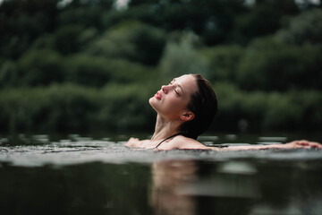  beautiful woman swims in the water of a lake river, swimming lessons.