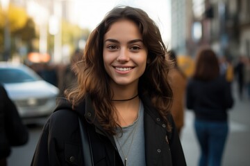 Canvas Print - Smiling young brunette posing at a beautiful city looking at the camera